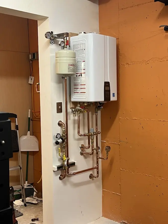 Plumbing technician inspecting water heater connections in Ione